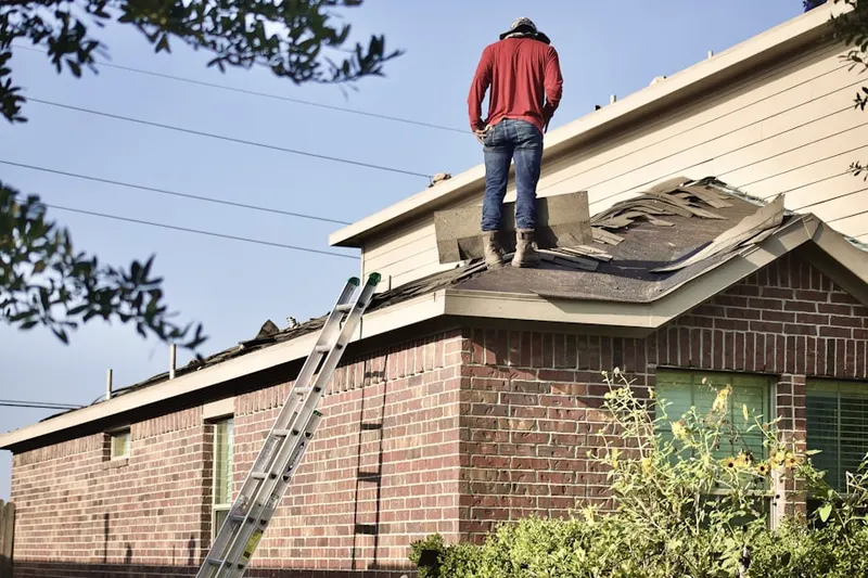 Professional roofer working on a residential roof in Dundee Village